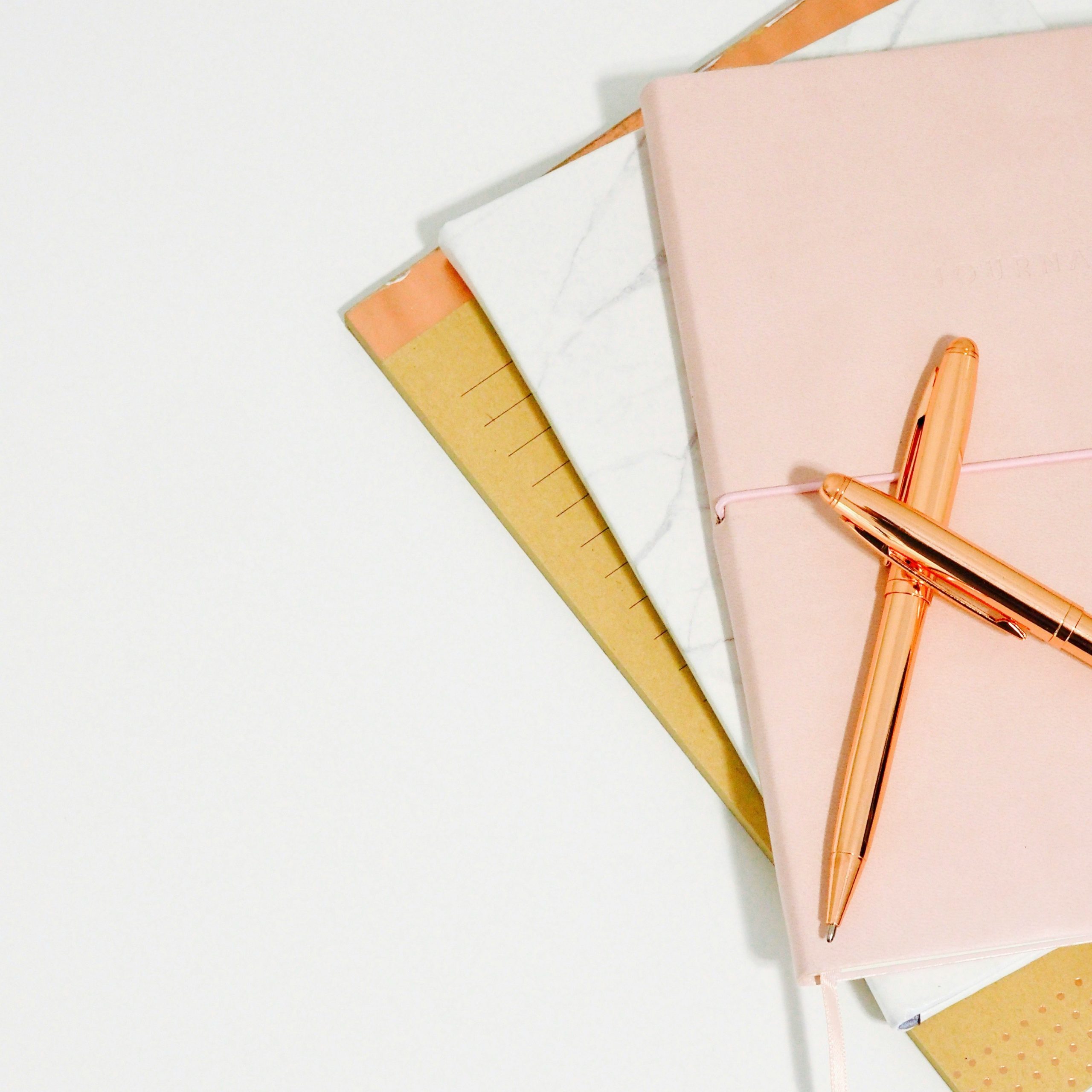 Notizbücher und zwei Stifte in sanften Farben, symbolisieren Kreativität und Organisation, begleitet das Kontaktformular.